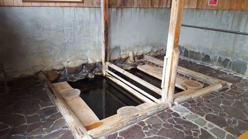 Dark water and an atmospheric bathhouse at Misasa Onsen's Kabuyu.